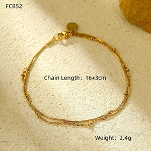 Detail shot of golden double-layer chain bracelet with charms and size specifications