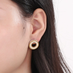 Close-up of rose gold circular earring with crystal pavé on female model's ear