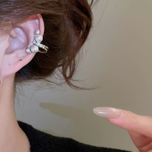 Detailed view of silver zircon pearl ear cuff worn on the ear bone without piercing
