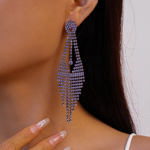 Close-up of elegant purple rhinestone fringe earrings worn by a model in a macro view