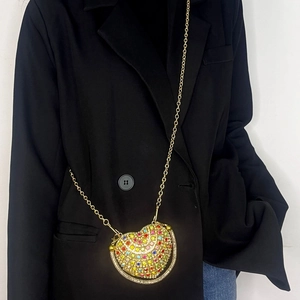 Close-up of heart-shaped mini bag with colorful rhinestones and golden chain strap