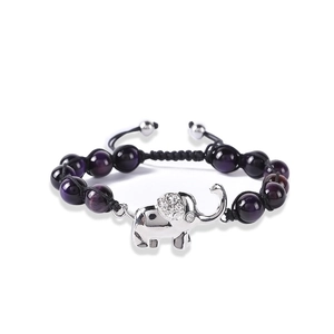 Macro shot of purple beaded bracelet featuring a silver elephant charm with white crystals