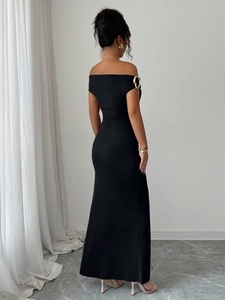 Detailed back view of a black off-shoulder maxi dress with gold ring buckle accents
