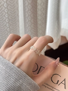 Close-up of minimalist silver flower cluster open ring on finger for a stylish look