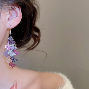 Gros plan de boucles d'oreilles papillon à glands avec dégradé coloré et dentelle ajourée