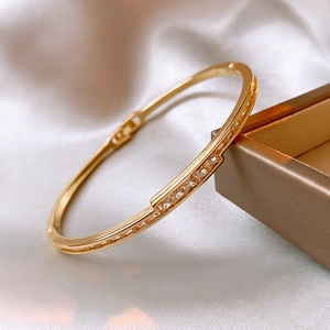 Detailaufnahme des goldenen Edelstahl-Armbands mit Zirkonia auf Seidenuntergrund