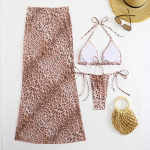Flat lay of leopard print bikini set with mesh long skirt and beach accessories
