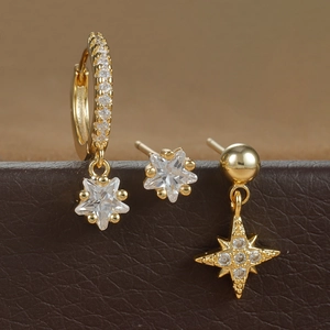 Macro detail of gold star earrings set with micro-inlaid cubic zirconia on leather