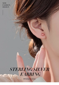 Close-up of model wearing S999 sterling silver round red ruby stud earrings with four-prong setting