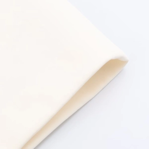 Primo piano della trama in maglia color crema di un abito a fascia alla moda