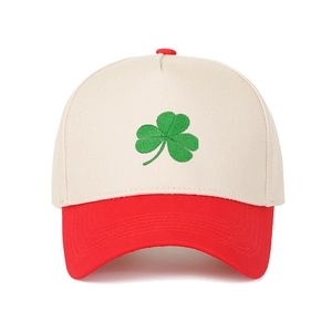 Detailed close-up of a two-tone baseball cap with green clover embroidery on the front