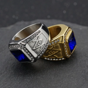 Detailed view of Masonic steel rings with blue square gems on dark stone background