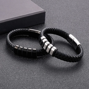 Détail de bracelets en cuir tressé noir avec boucles magnétiques en acier noir et argent