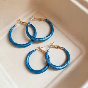 Klein-Blaue Marmor-Resin-Creolen mit goldenen Nadeln auf beigem Tablett
