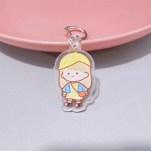 Detail of cute acrylic girl keychain with silver metal ring on a soft pink background