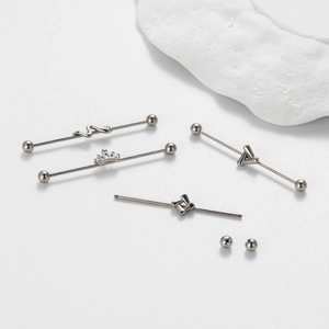 Detailed set of silver industrial piercings with crown, snake and geometric designs
