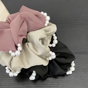 Trois chouchous élégants en satin rose, beige et noir avec détails de perles blanches