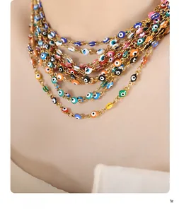 Close-up of bohemian layered gold necklace with colorful evil eye charms on model