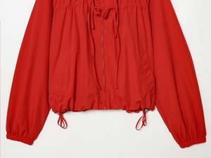 Detail of red nylon jacket showing zipper closure and adjustable drawstring chest design