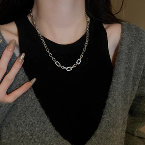 Detail of chunky geometric link necklace with pave-set cubic zirconia on a model