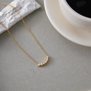 Elegant 18K gold-plated stainless steel necklace with seven white pearls on curved pendant