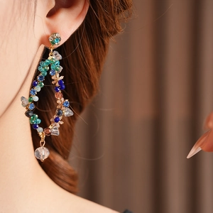 Close-up of vintage tassel earrings with colorful beads and gold finish on a model