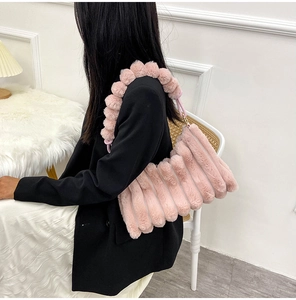 Side view of a large plush tote bag in pink color-blocking held by a model on plain background