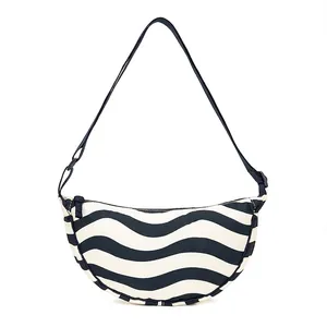 Macro shot of blue and white wave pattern fabric on a large capacity crossbody bag