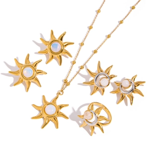 Flat lay of gold sun and moon jewelry set with opal stones on white background