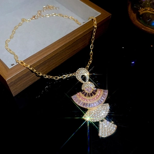 Macro shot of luxury gold fan-shaped necklace pendant with pink and clear crystals
