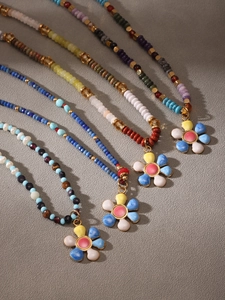 Close-up of colorful floral beaded necklaces with enamel flower charms and mixed stone beads