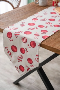 Detail of Christmas table runner with red festive ball patterns on linen texture