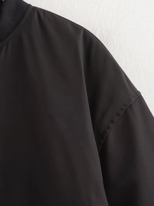 Détail des coutures d'épaule et du col côtelé d'une veste de baseball plissée noire