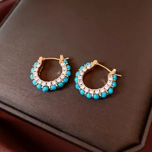 Gold-plated C-shaped earrings with turquoise stones and cubic zirconia in a vintage style