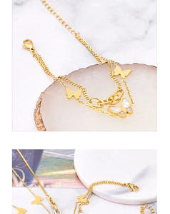 Detail of 18k gold butterfly necklace with layered chains and shell inlay texture
