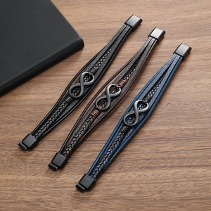 Close-up of vintage multi-layer leather bracelets with metal infinity symbol on wood