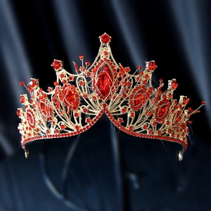 Detail of luxury bridal crown with red rhinestones and gold metal base for weddings
