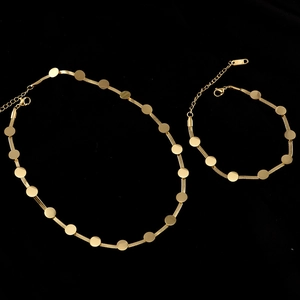 Détail de la parure collier et bracelet en maille serpent dorée avec breloques disques