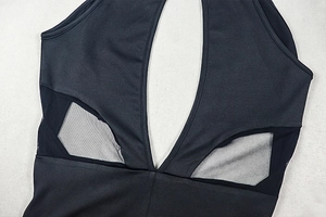 Close-up of black cutout jumpsuit featuring mesh splicing and elastic fabric details