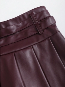 Detail view of burgundy PU leather pleated skirt waist with high-quality stitching