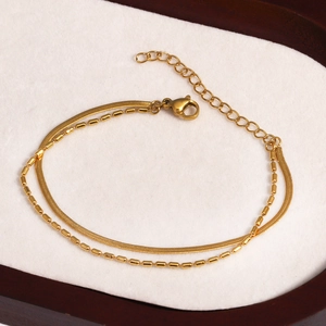 Vue détaillée d'un bracelet doré à double chaîne avec maille serpent et billes