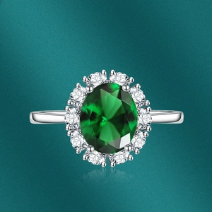 Macro shot of green oval emerald-style ring with sparkling cluster halo set in silver