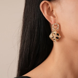 Gros plan de boucles d'oreilles léopard vintage avec strass brillants sur l'oreille