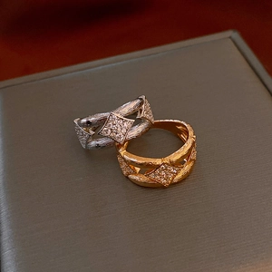 Macro shot of silver and gold textured rings with zircon inlaid rhombus detail