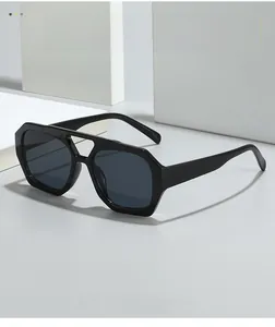 Détail de lunettes de soleil à double pont irrégulier avec monture noire et verres gris