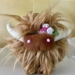 Close-up of Highland cow plush toy featuring fluffy brown fur and cute floral decorations