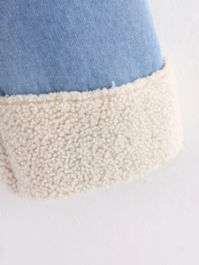 Close-up of blue denim jacket texture with soft white fleece lining and sharp details