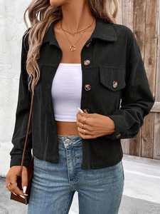 Nahaufnahme der schwarzen Cord-Stoffstruktur und Knopfdetails an einer Damenjacke