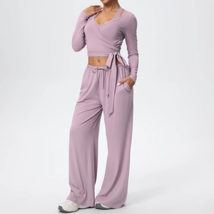 Détail du haut cache-cœur à nouer et pantalon de yoga large en couleur rose fumé