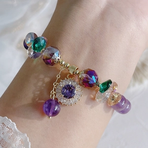 Natural amethyst bracelet with zircon flower charms shown on a woman wrist